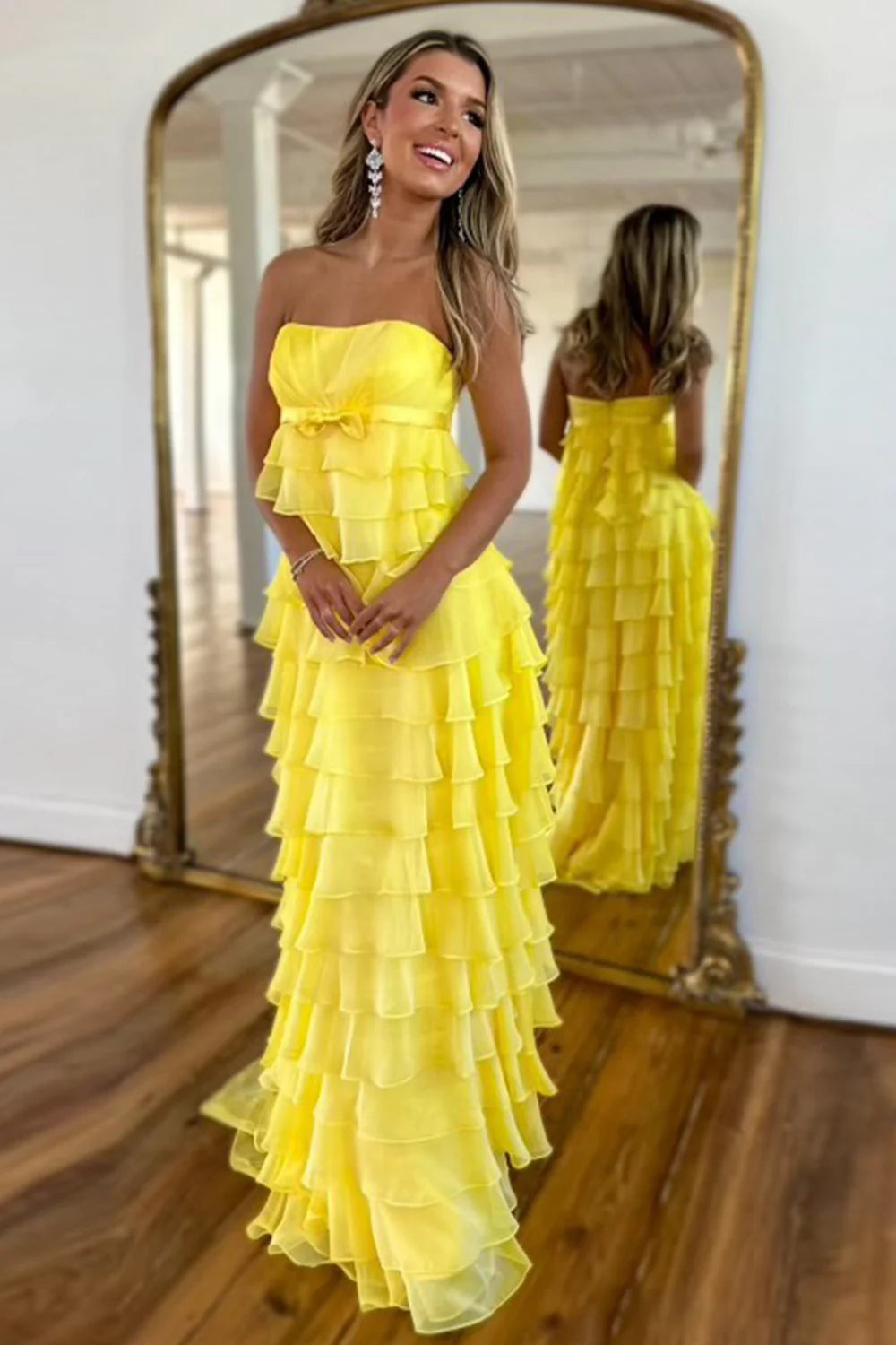 Yellow A-line strapless prom dress with tiered skirt and corset back.