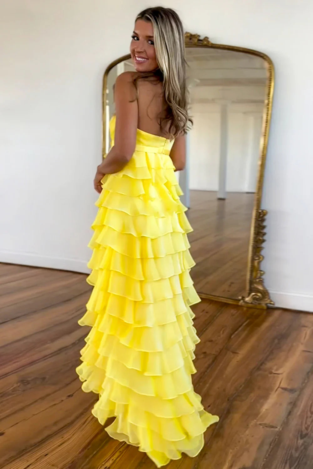 Back view of yellow A-line tiered prom dress with zipper closure.