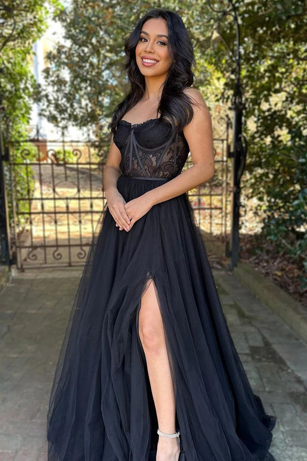 Black A-line strapless prom dress with high split, side view.