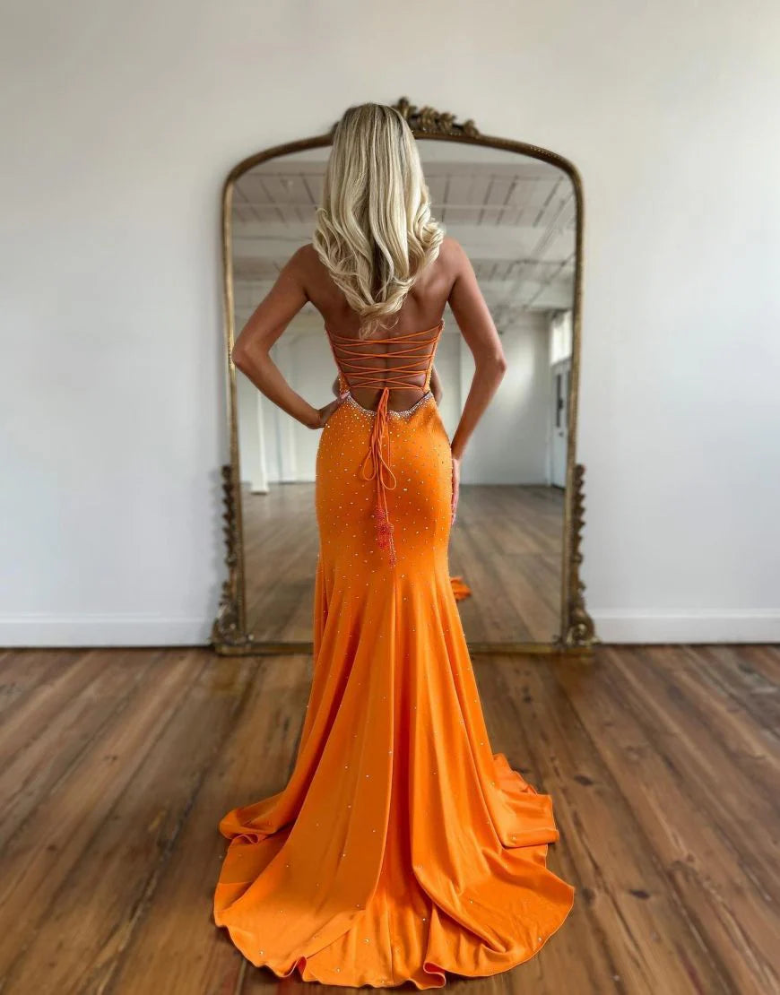 Side view of the orange mermaid prom dress, showcasing the elegant train and leg slit.