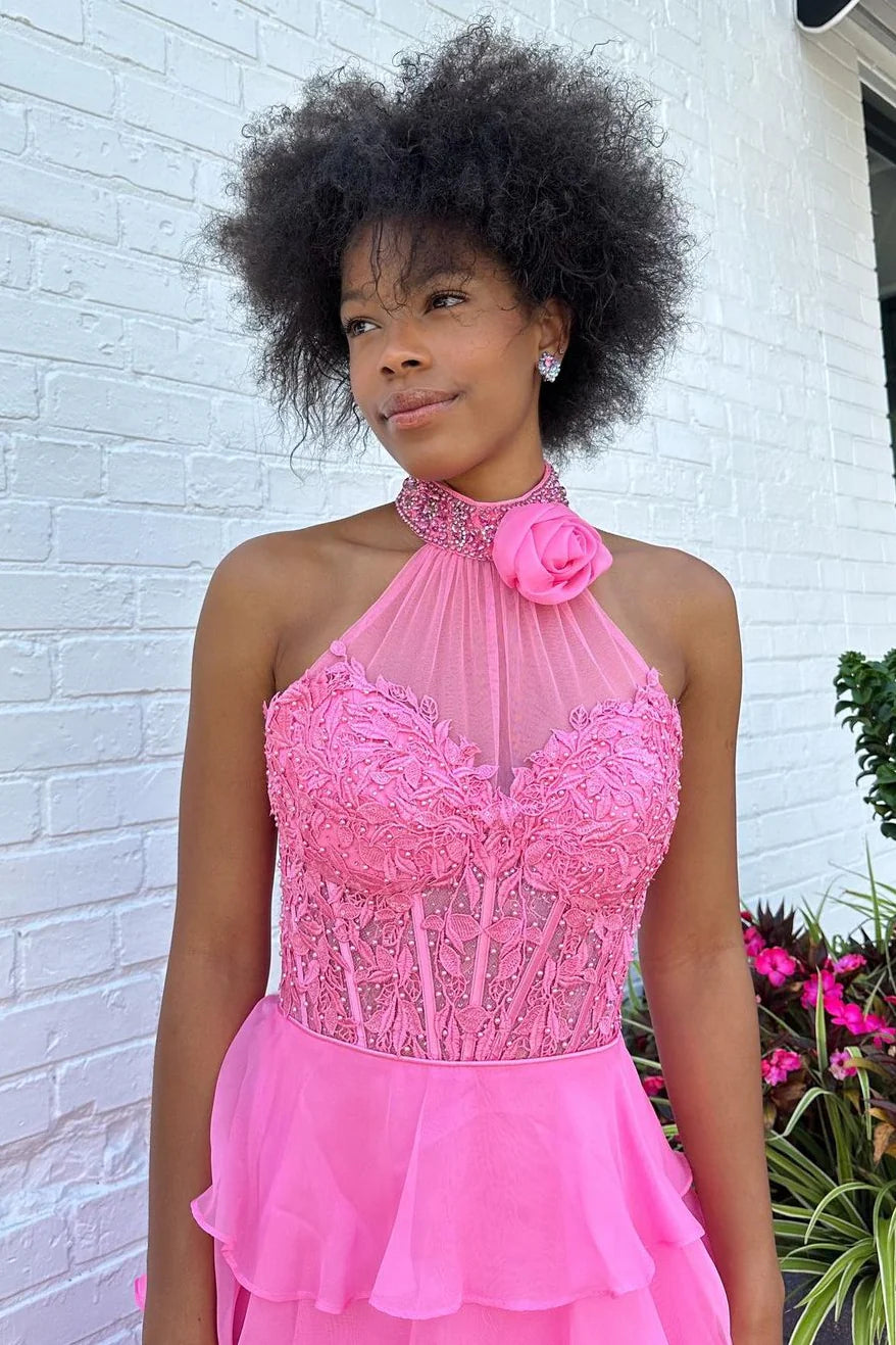 Close-up of the lace top and beaded halter neckline with rose detail on a pink prom dress.