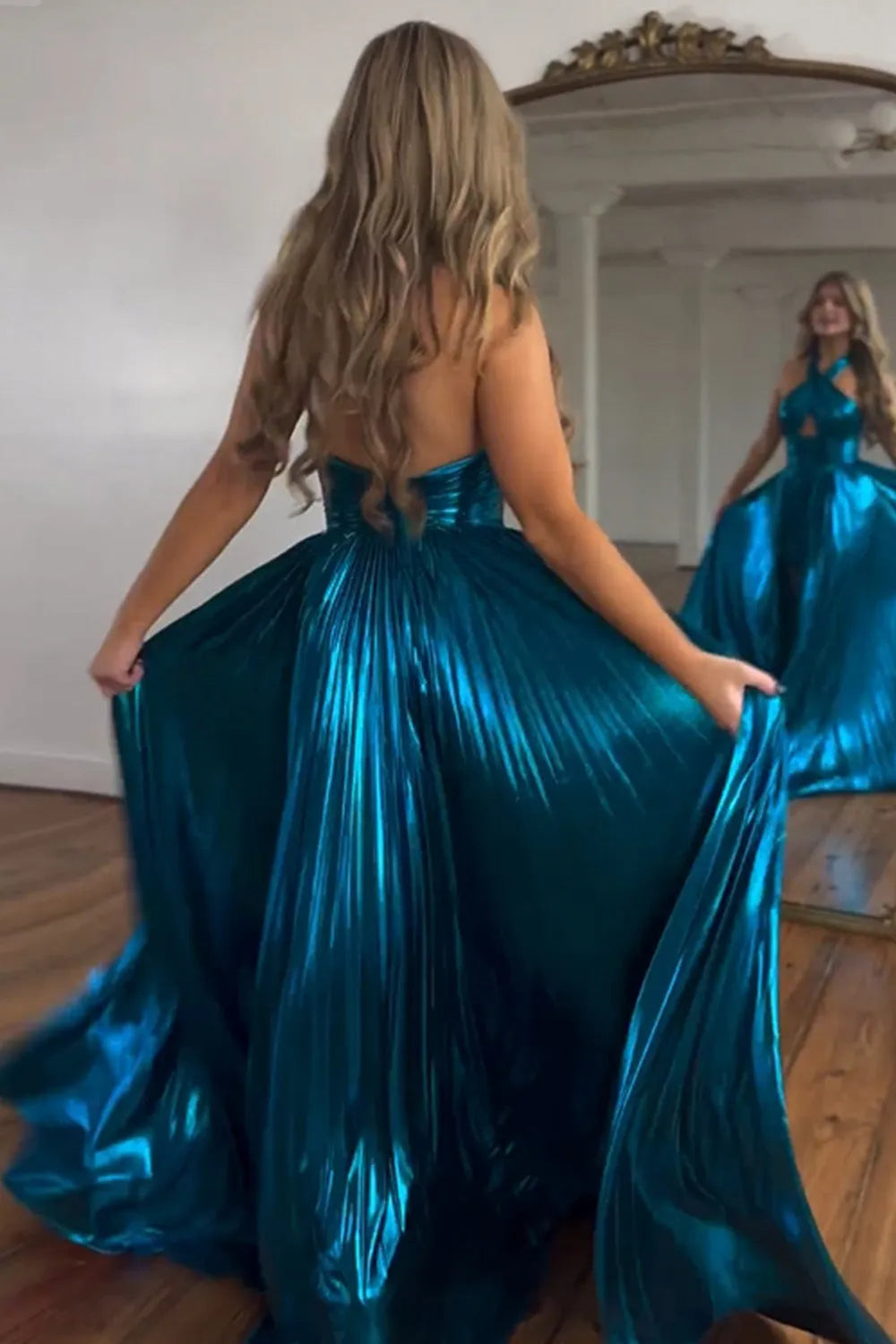 Back view of the metallic peacock blue halter neck prom dress, showcasing the open back.