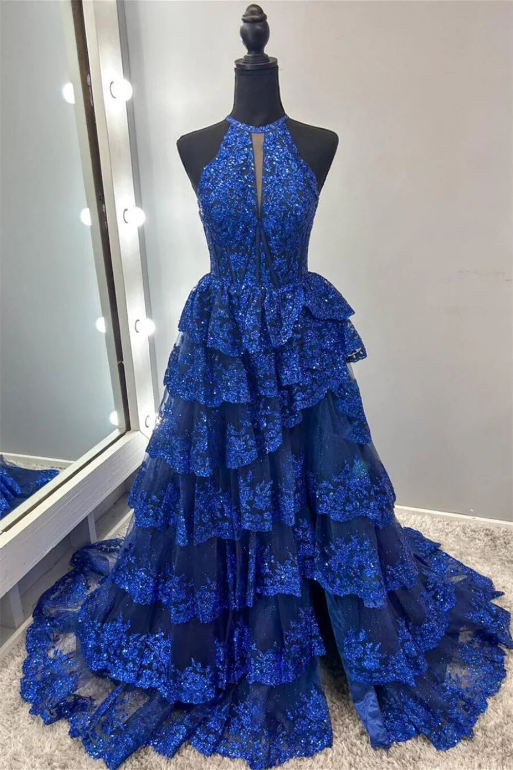 Royal blue A-line prom dress with halter neck, tiered lace, and corset bodice.