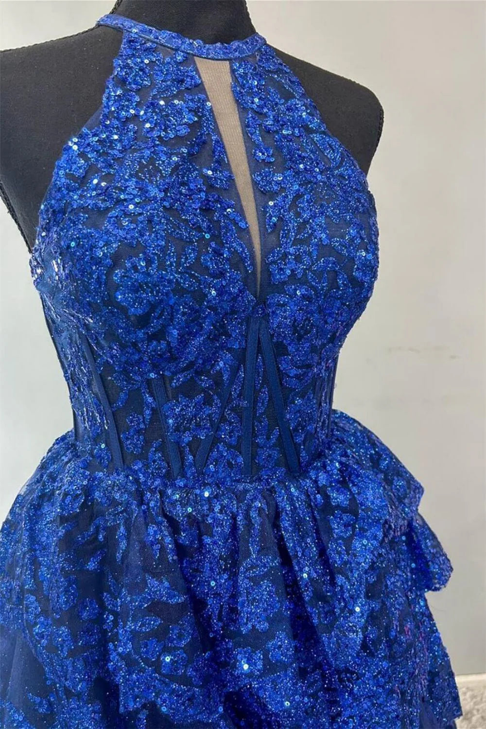 Elegant royal blue floor-length gown featuring a halter neckline and tiered lace skirt.