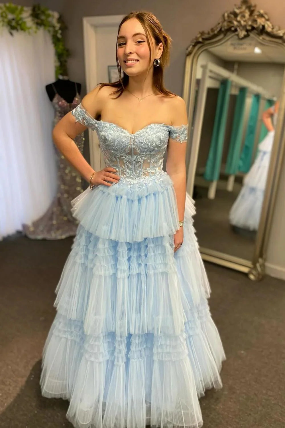Light blue A-line prom dress with off-the-shoulder neckline, appliques, and corset bodice.