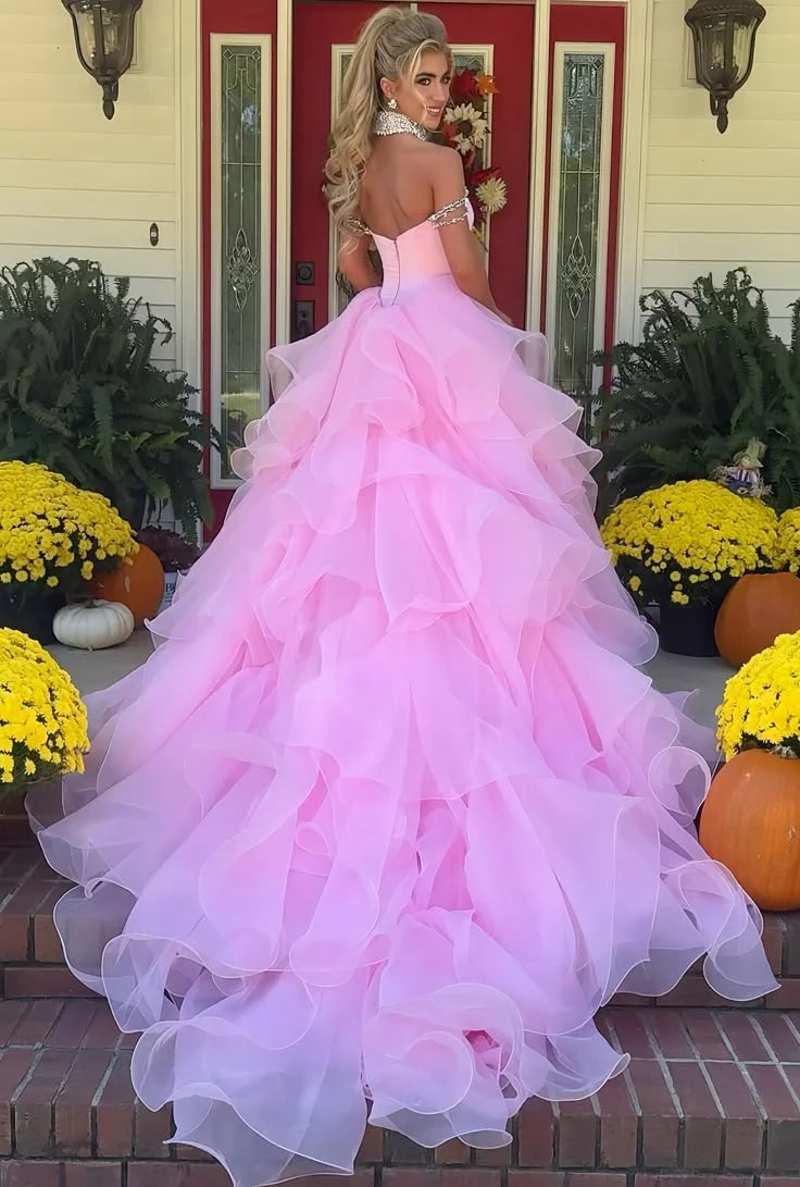 Back view of a model in the pink off-shoulder A-line prom dress, highlighting the zipper and train.