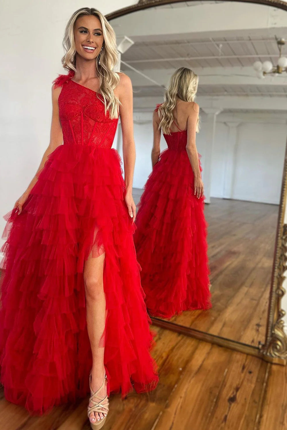 Red A-line one-shoulder prom dress with lace corset, ruffle tiers, and a high split.