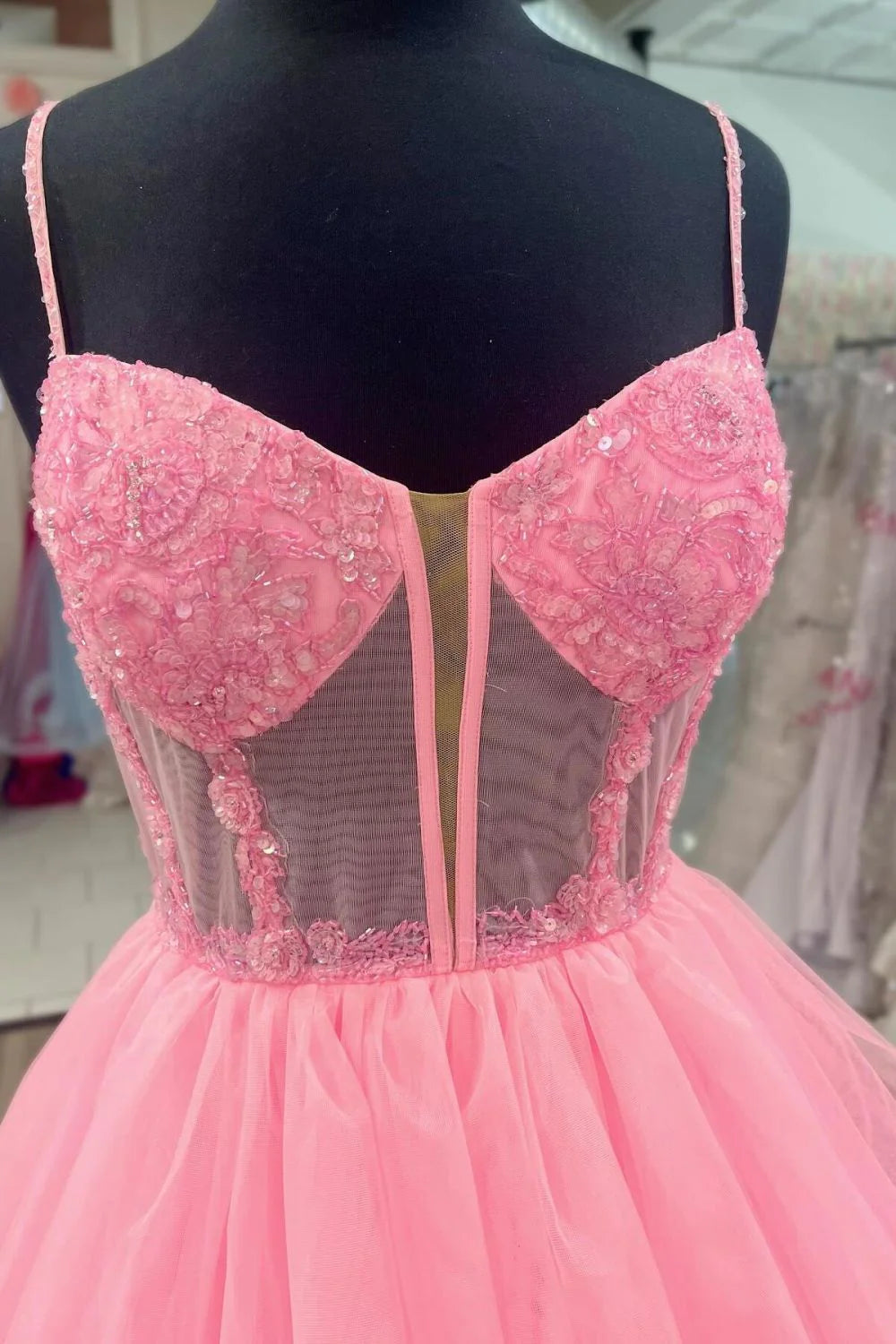 Back view of pink A-line prom dress showing tiered tulle and corset detailing.