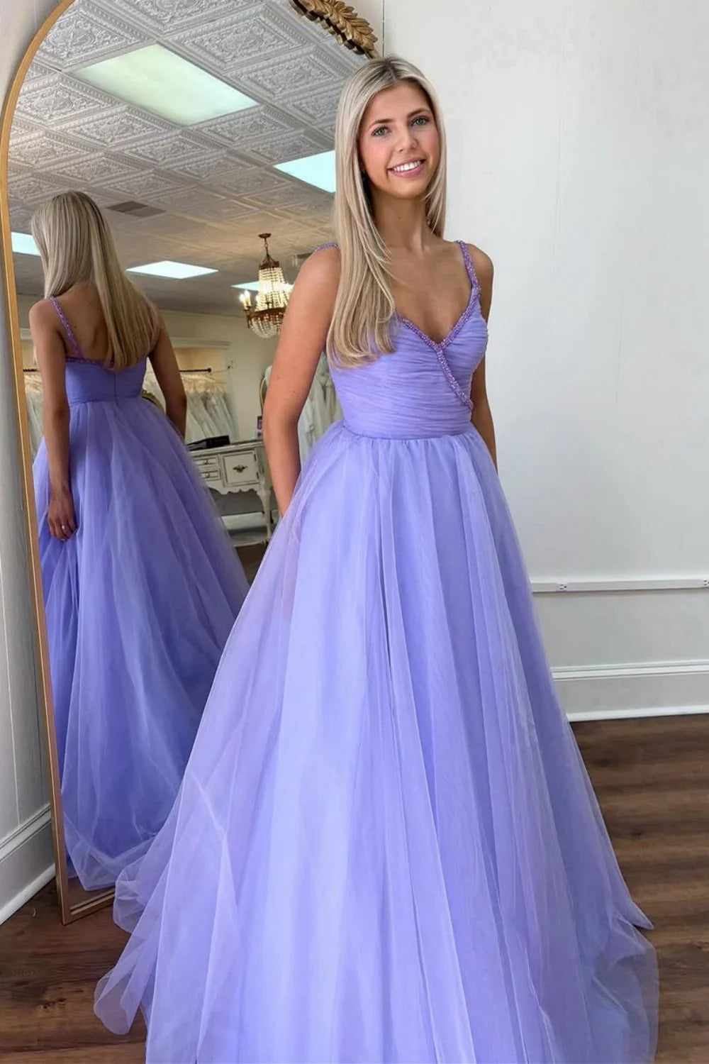 Elegant purple A-line prom dress with spaghetti straps, beaded details, and a flowing tulle skirt.