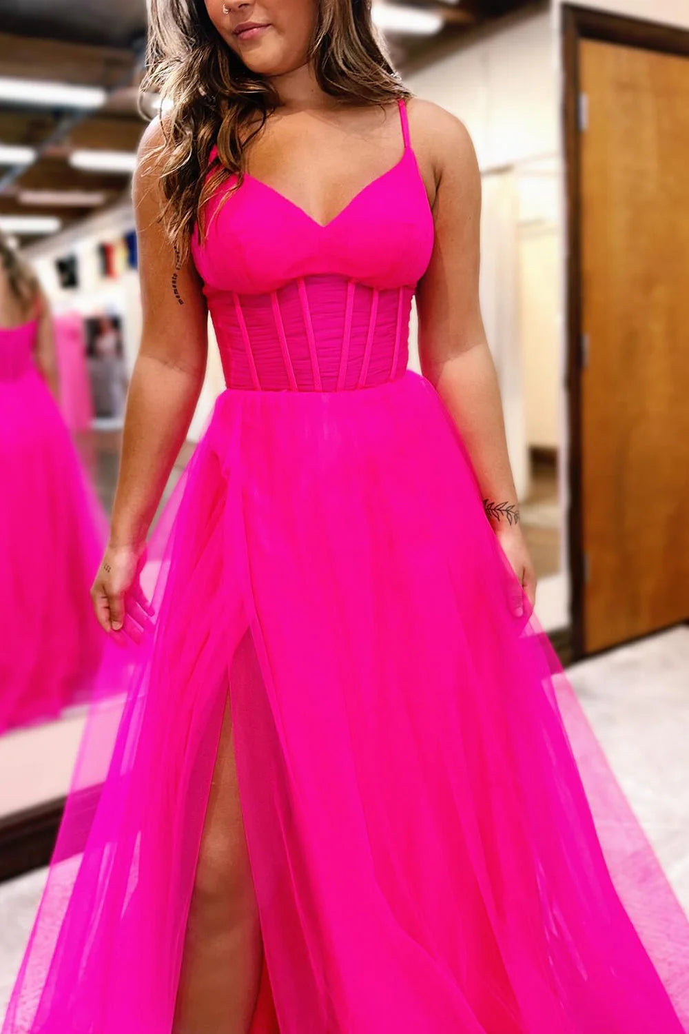 Back view of a hot pink corset tulle prom dress.