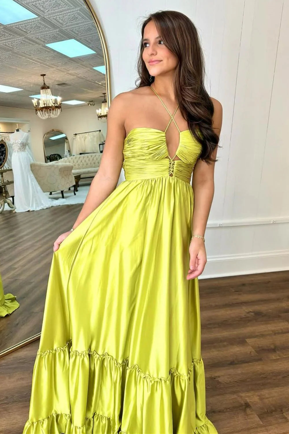 Yellow A-line prom dress with spaghetti straps and lace-up back detail.