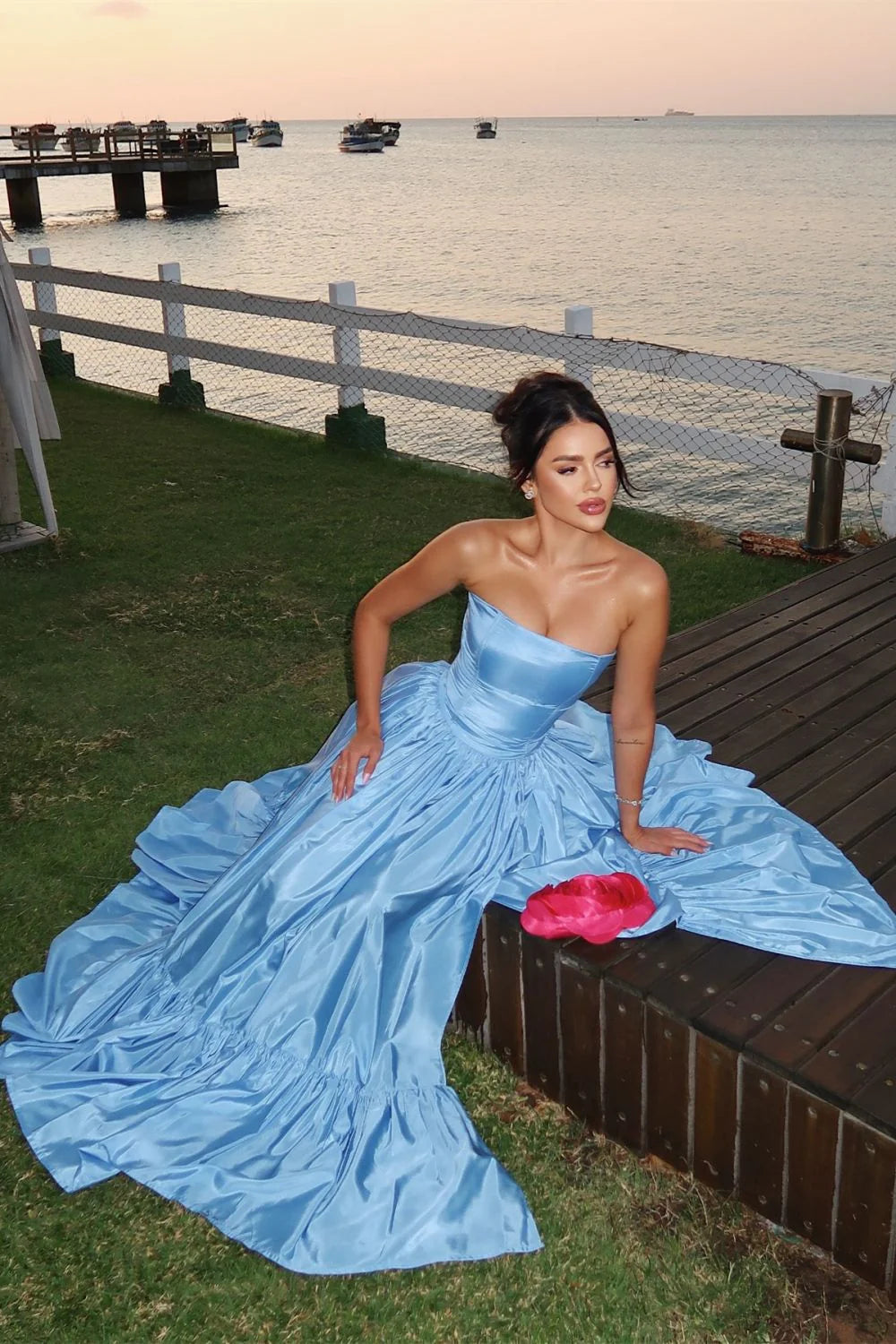 Full length view of the blue A-line strapless satin prom dress, highlighting the flowing skirt and high split.