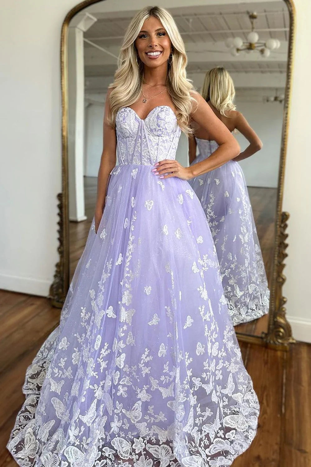Woman in a lilac A-line prom dress with sweetheart neckline and appliques, showing the back zipper detail.