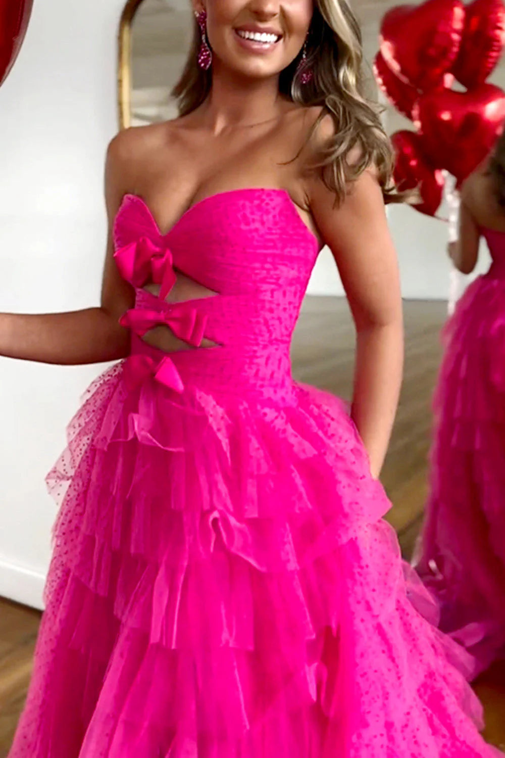 Close-up of the sweetheart neckline and bowknot detail on the fuchsia prom dress.