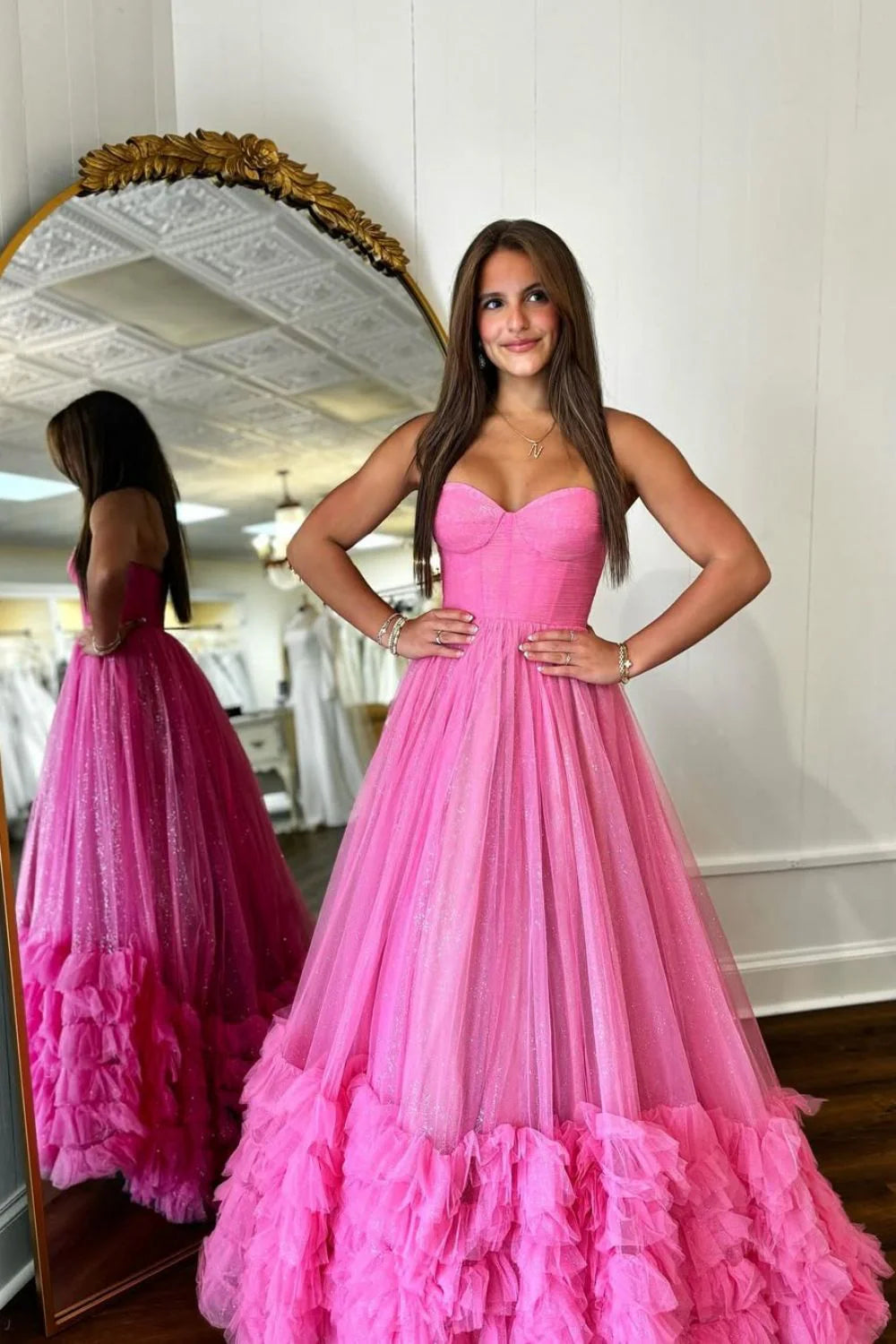 Full view of a pink A-line sweetheart prom dress featuring ruffle accents and sparkling glitter tulle.