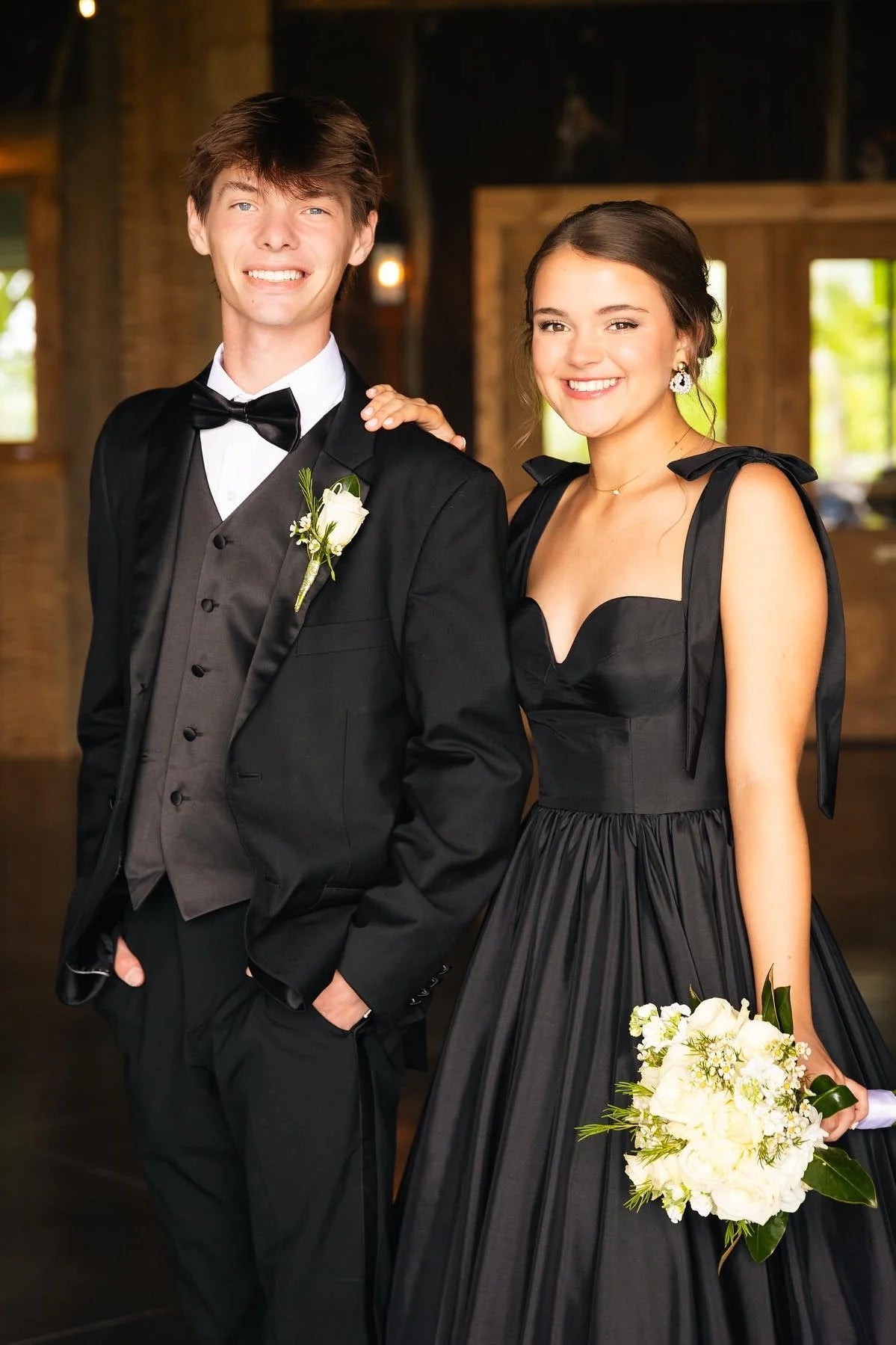 Front view of the black satin A-line prom dress, showcasing the sweetheart neckline and voluminous tiered skirt.