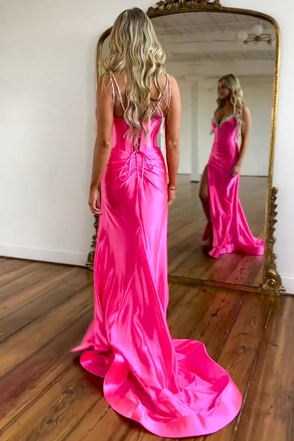 Side view of hot pink satin mermaid gown with high slit and sweep train.