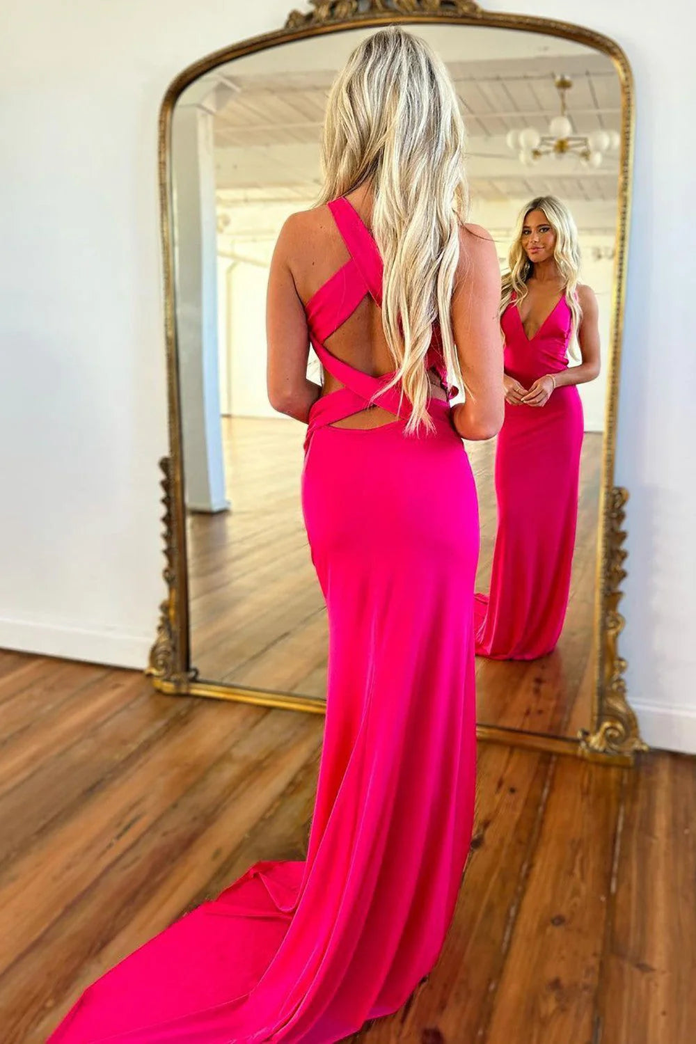 Model wearing a hot pink satin V-neck corset long prom dress, front view.