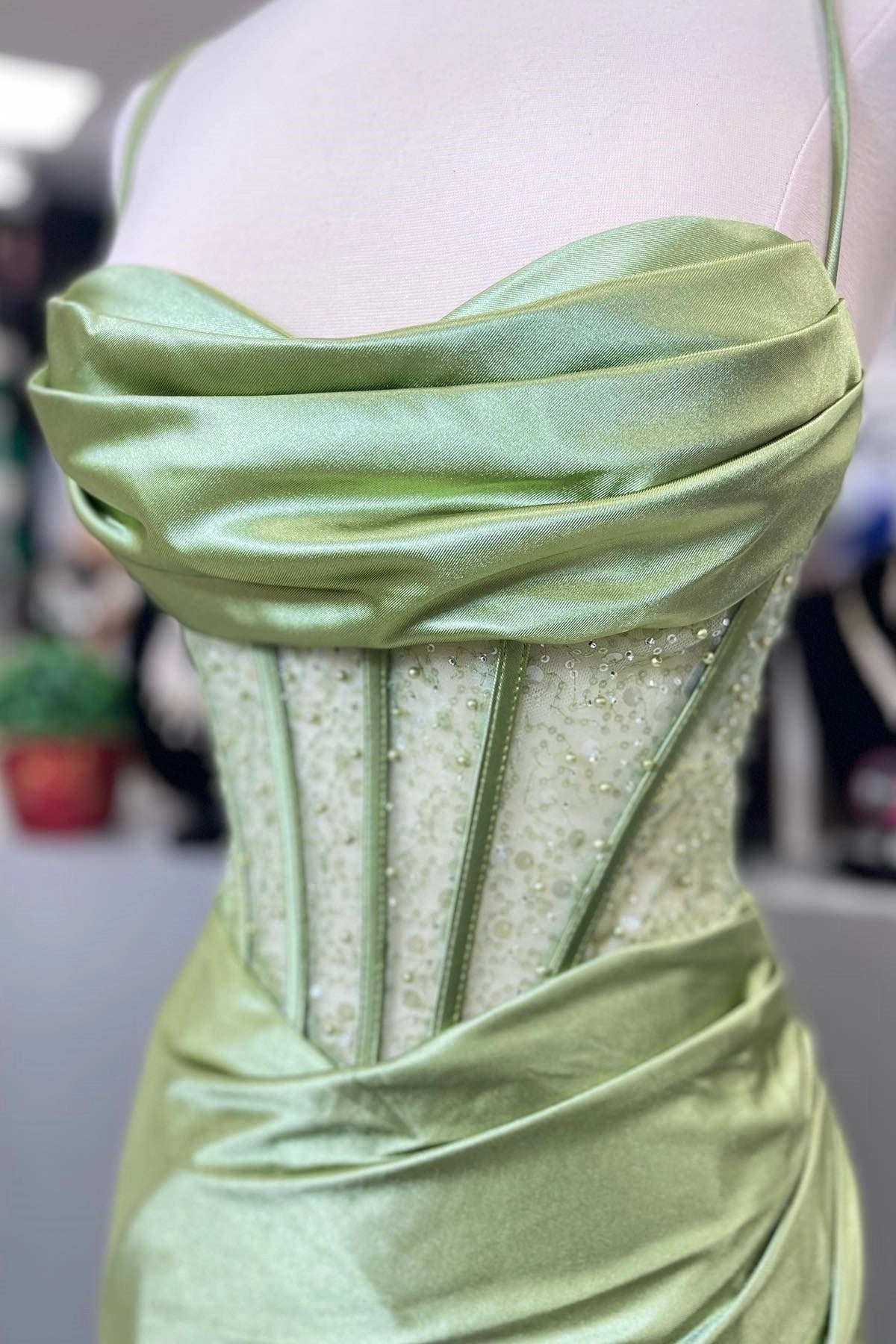 Green floor-length prom dress featuring a corset bodice and high leg split.