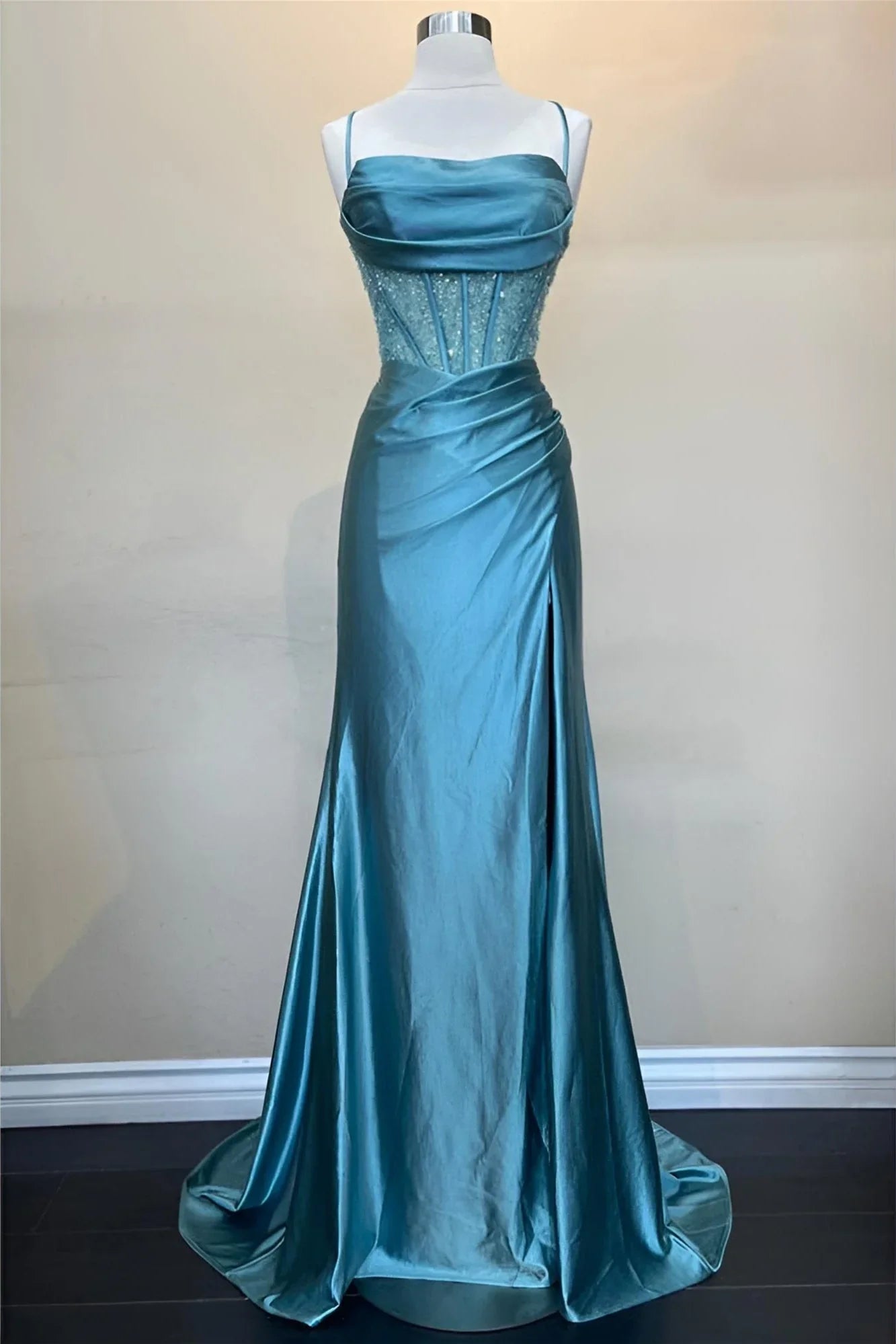 Close-up of the green corset bodice with spaghetti straps and beaded details.