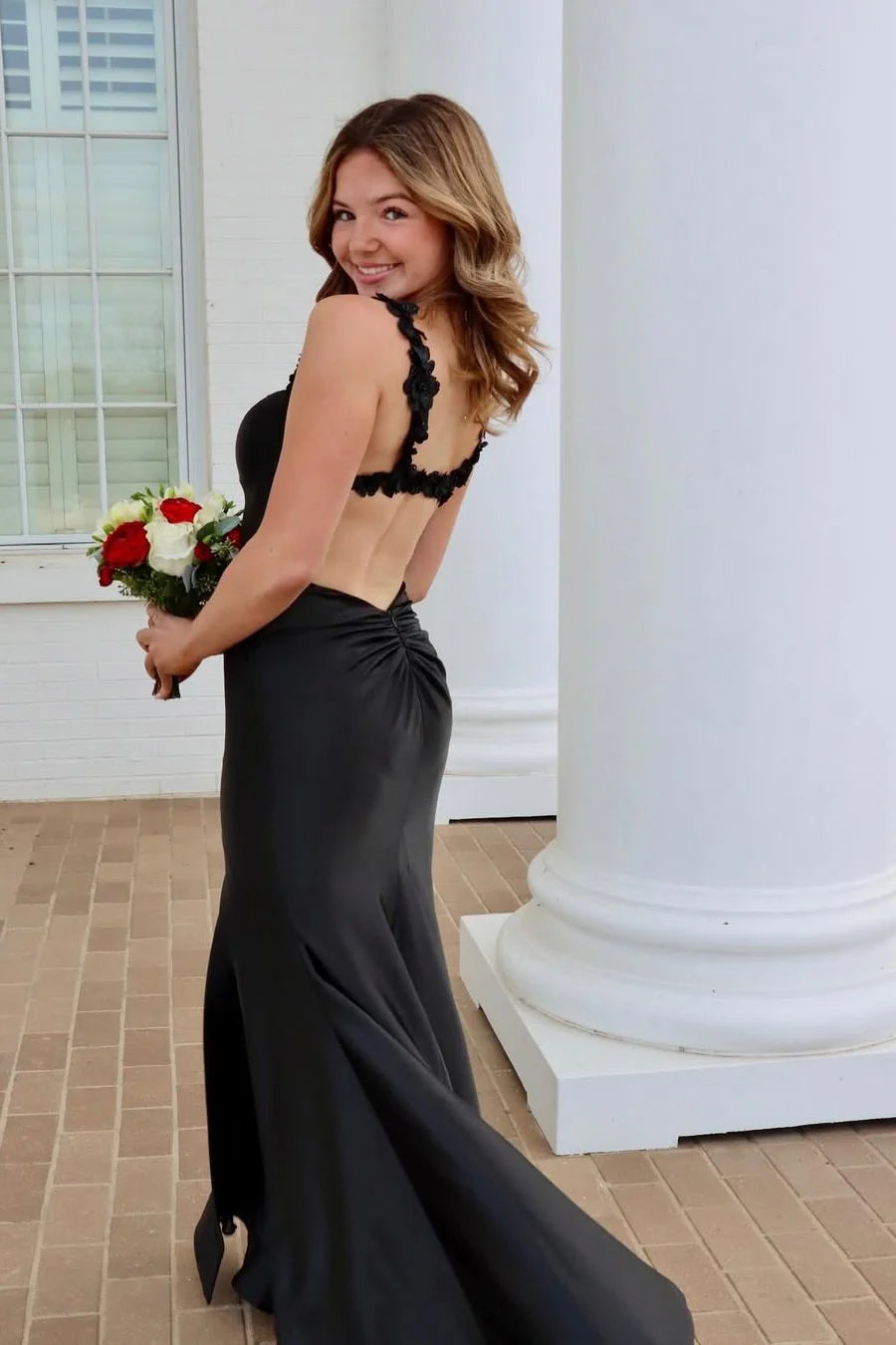 Rear view of a red satin mermaid gown, showcasing the open back design.