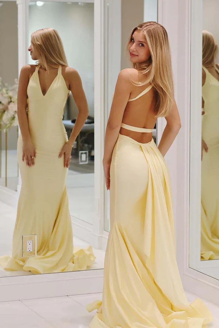 Back view of a yellow mermaid gown, showcasing the open back and sweep train.
