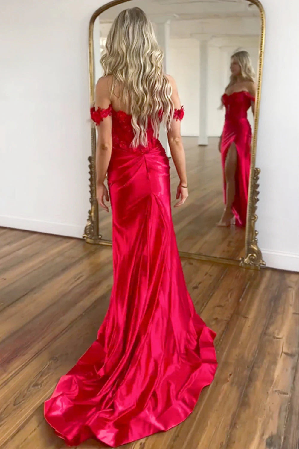 Red mermaid prom dress with off-shoulder neckline, floral beading, and high split, side view.
