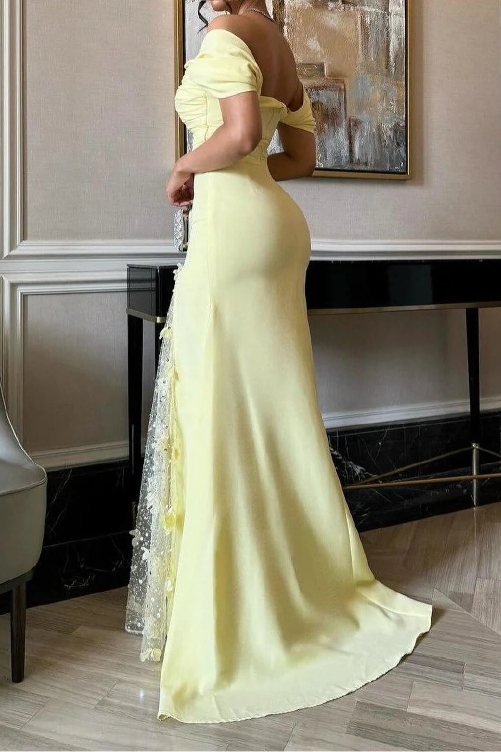 Close-up of yellow mermaid dress bodice, off-shoulder detail, and side split with floral panel.