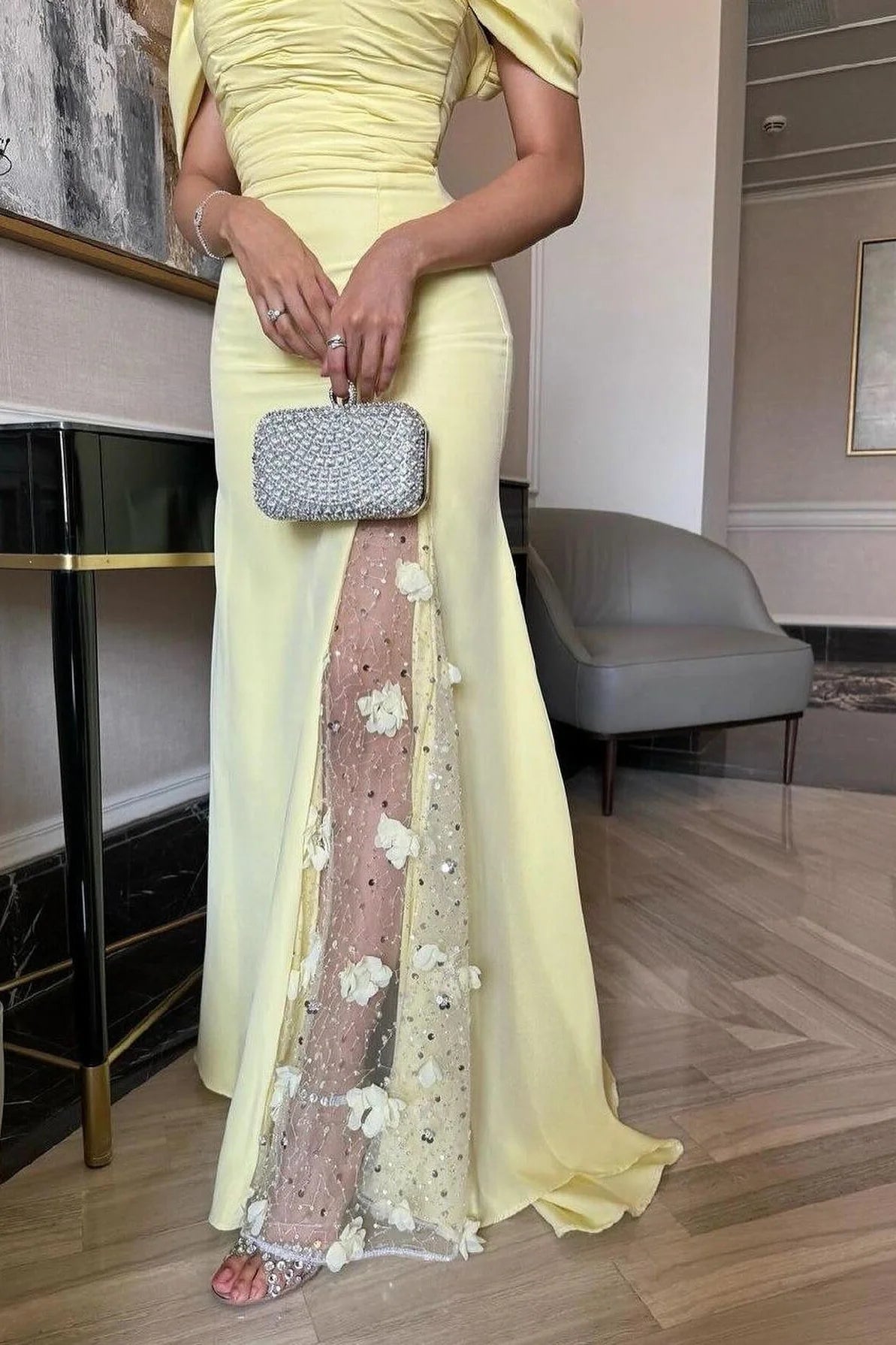 Front view of a woman wearing a sophisticated yellow mermaid prom dress.