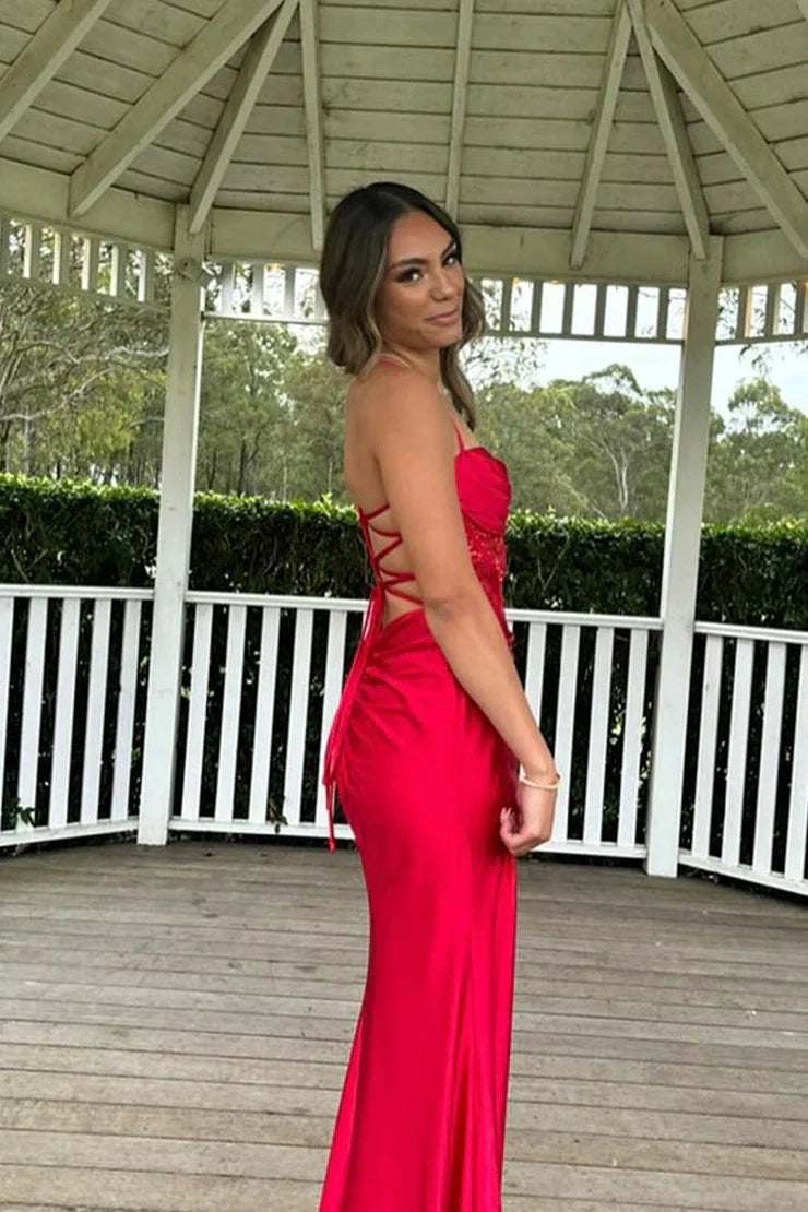 Side view of a red mermaid prom dress with spaghetti straps and floor-length skirt.