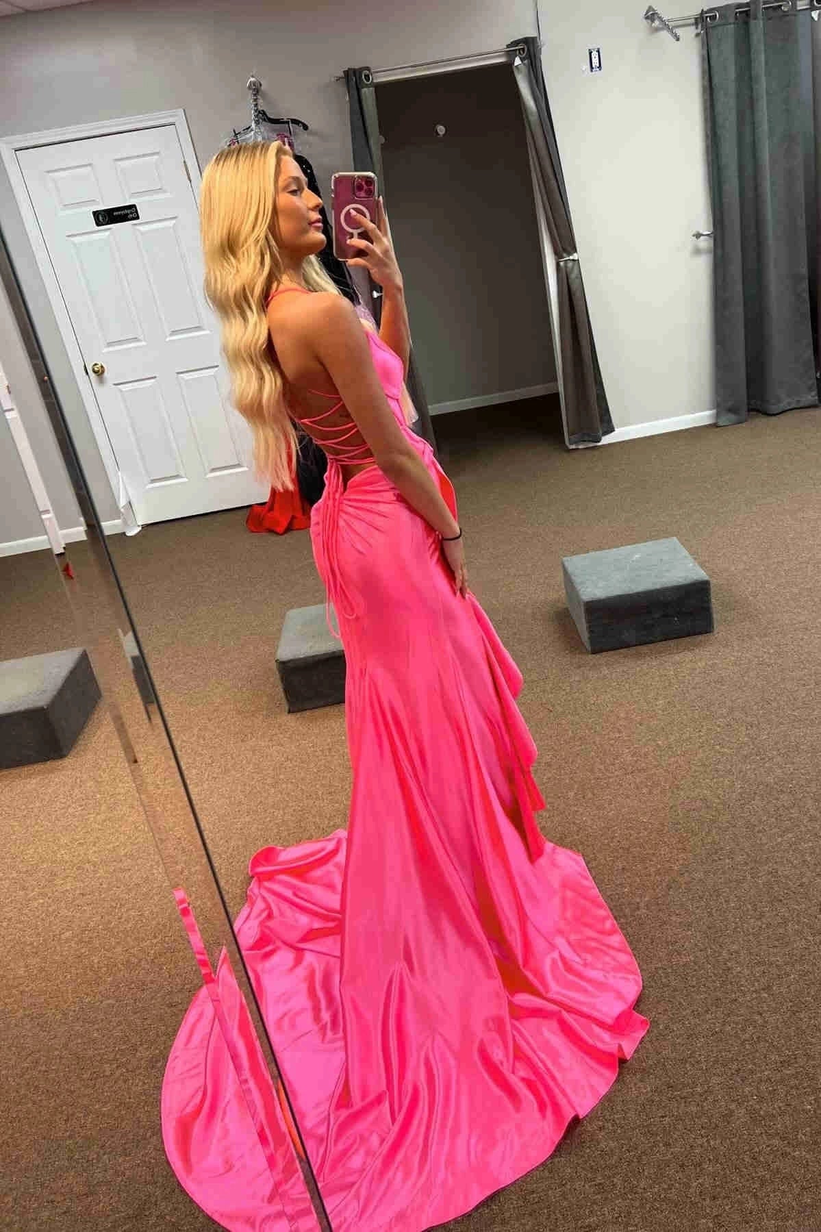 Back view of a model in a hot pink satin mermaid dress with a lace-up back.