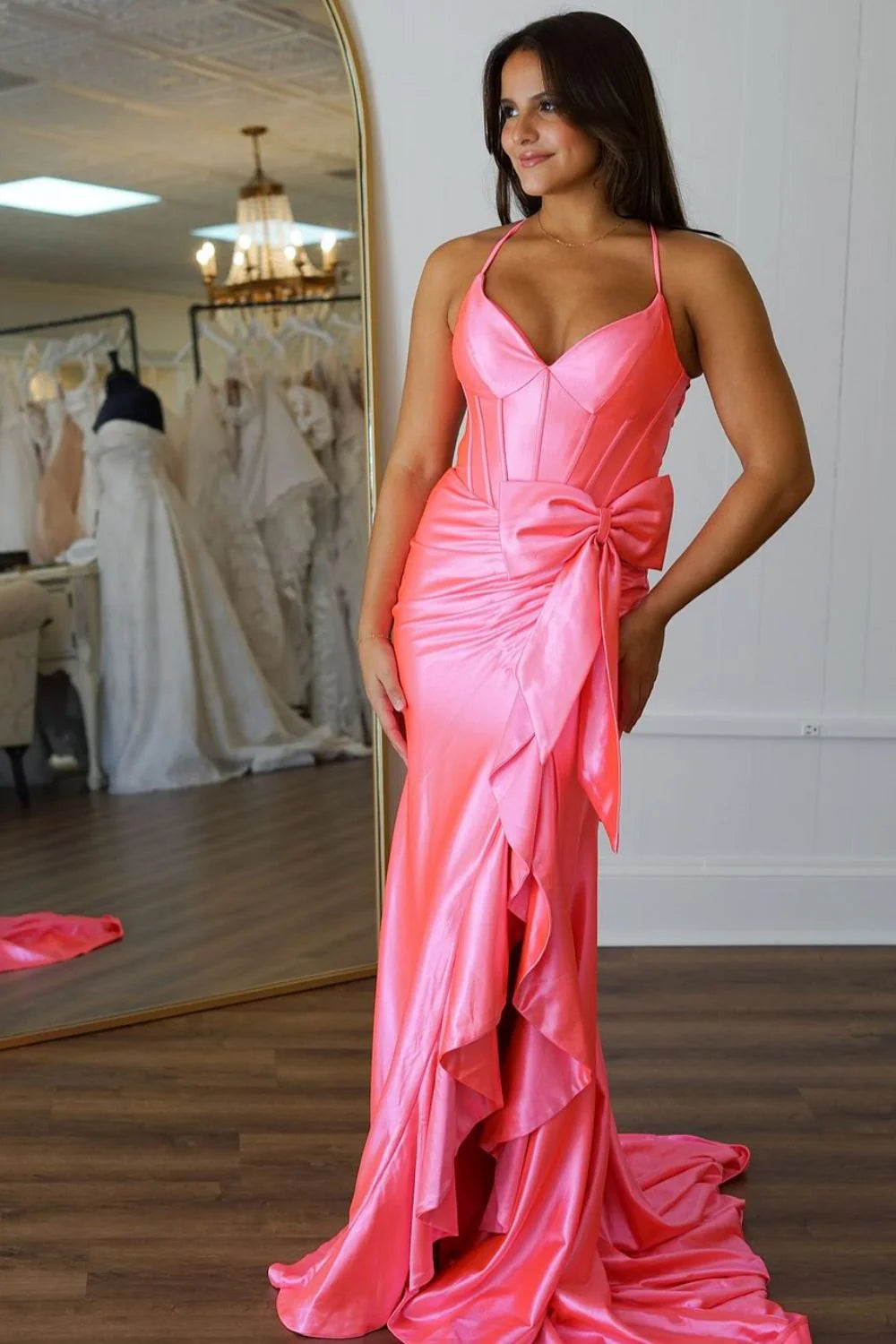 Model wearing an elegant pink mermaid prom dress with a bowknot and front slit.
