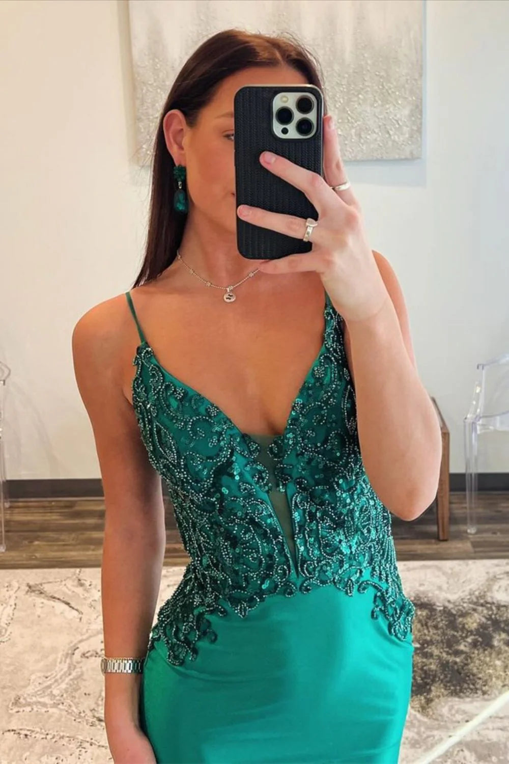 Front view of a dark green mermaid prom dress, showcasing the V-neckline and beading.