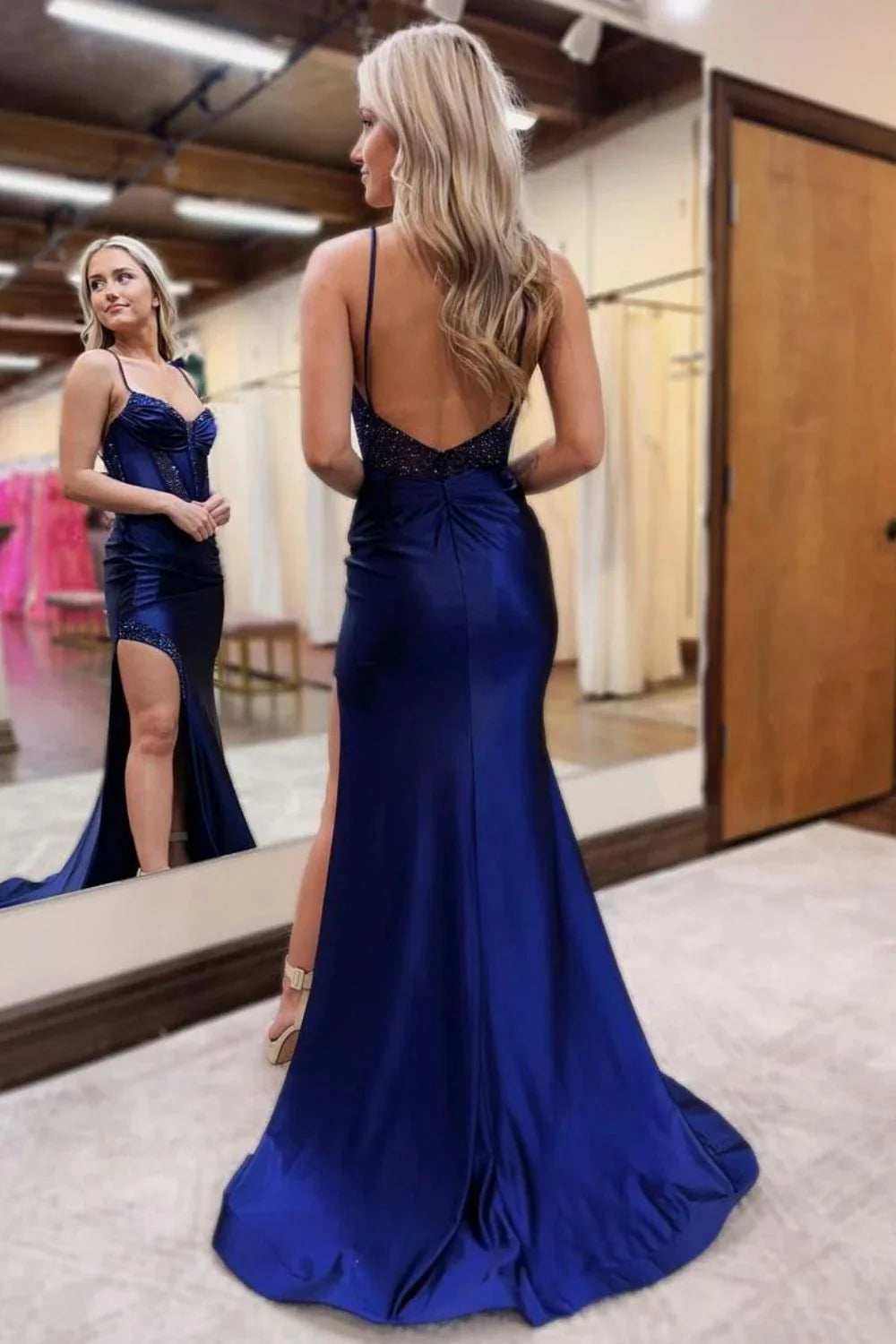 Navy mermaid prom dress with open back and delicate beading, side view.