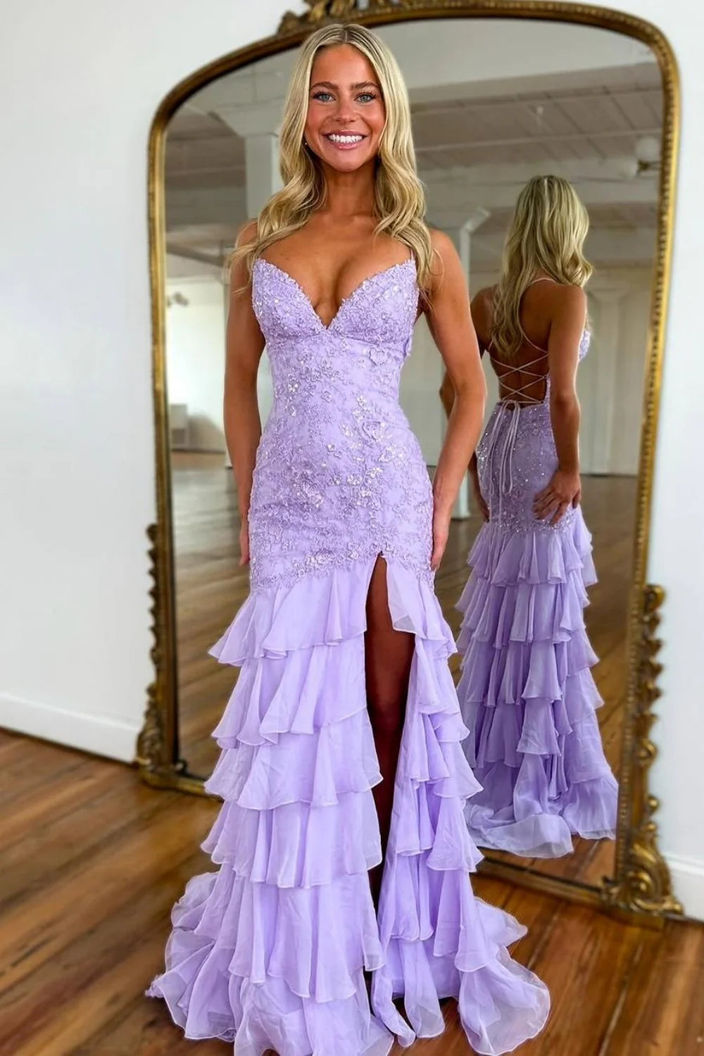 Woman in a lilac mermaid prom dress with spaghetti straps and ruffle lace train.