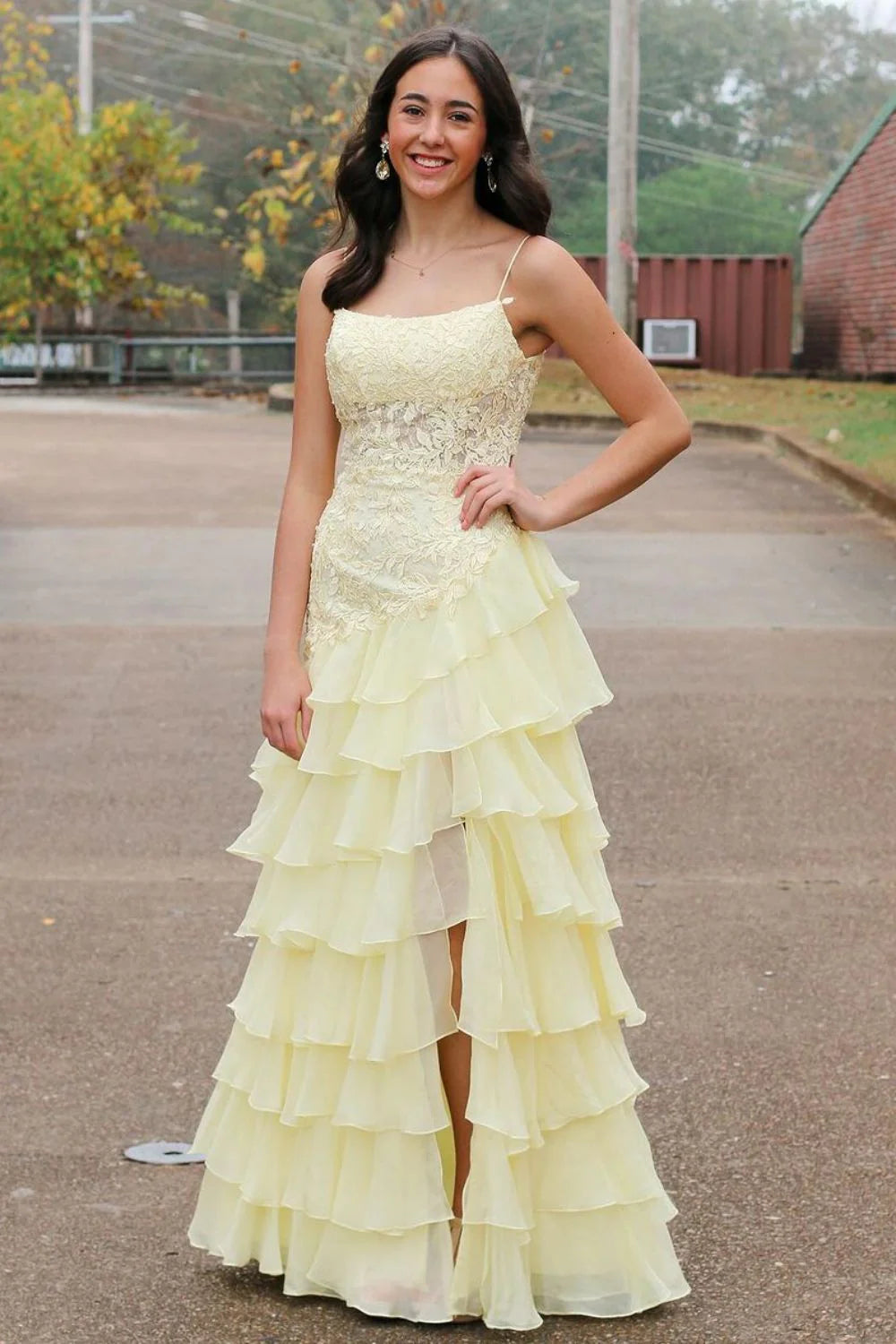 Yellow mermaid prom dress with spaghetti straps, lace applique, and high slit.