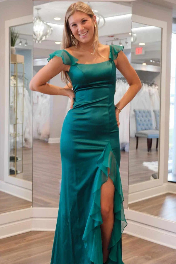 Model in a green mermaid prom dress with square neck, ruffles, and a high slit.