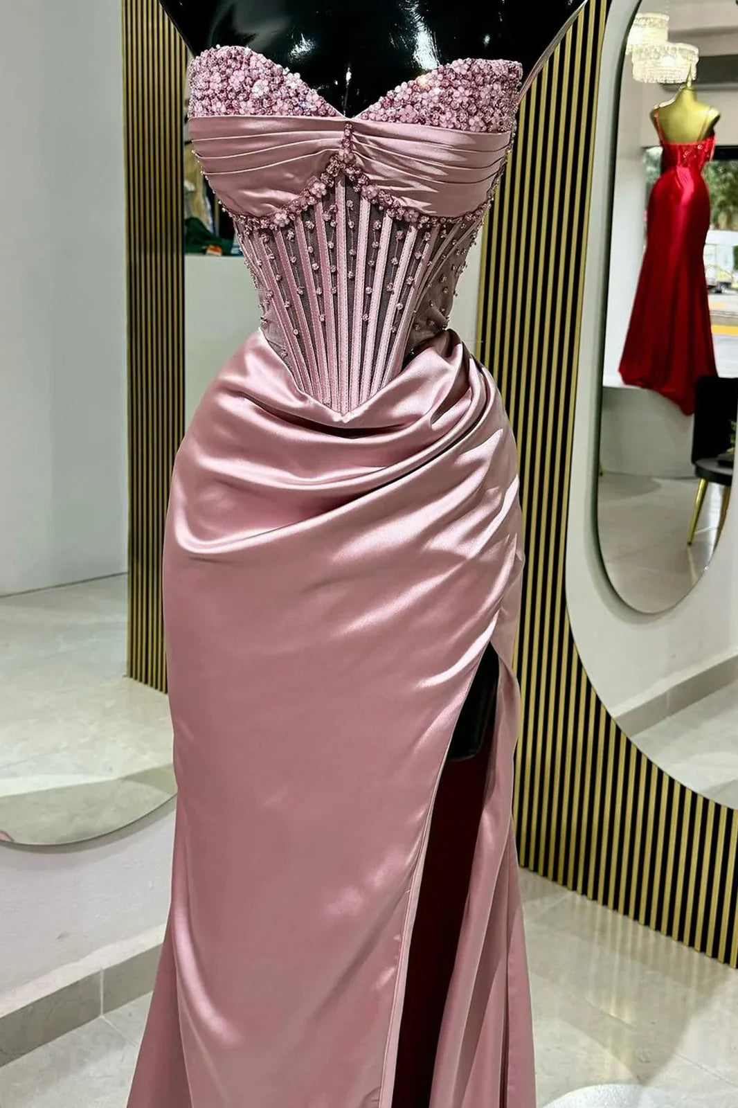Elegant pink mermaid prom dress with strapless beaded bodice and high slit.