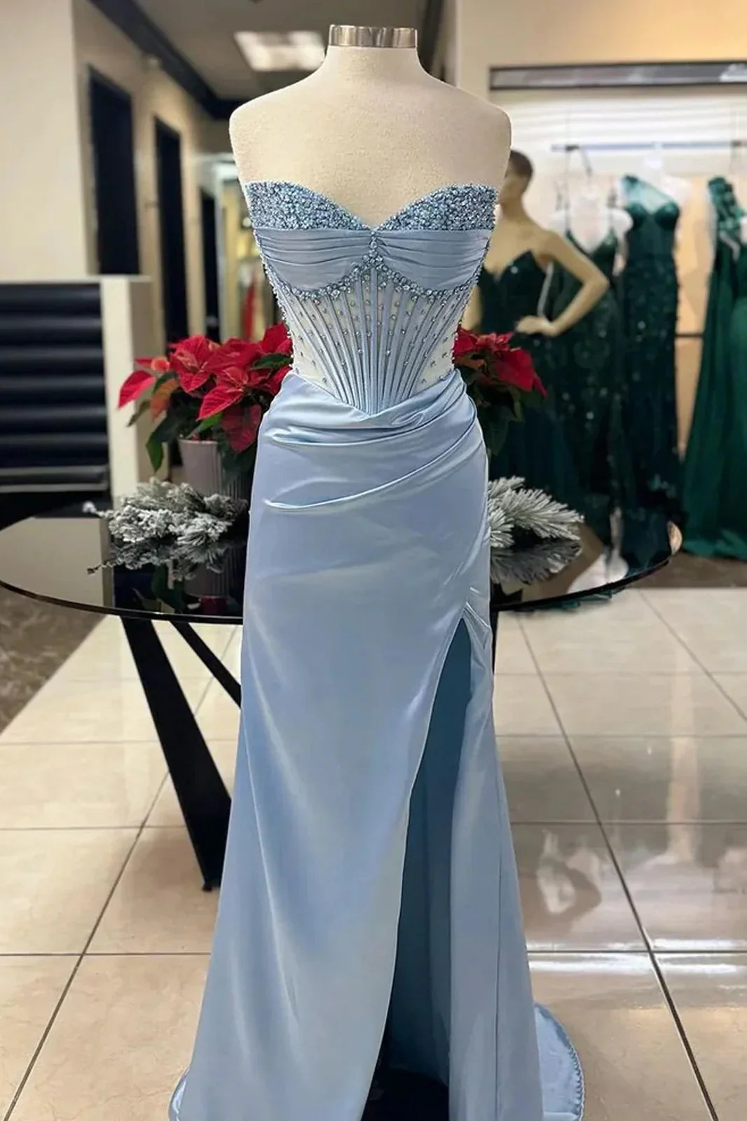 Full length view of a woman in a pink strapless satin prom dress with a high slit.