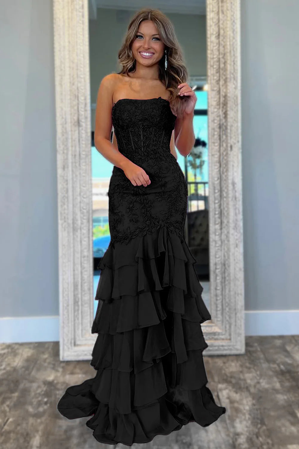 Model wearing a mint green mermaid prom dress with a flowing tiered skirt.