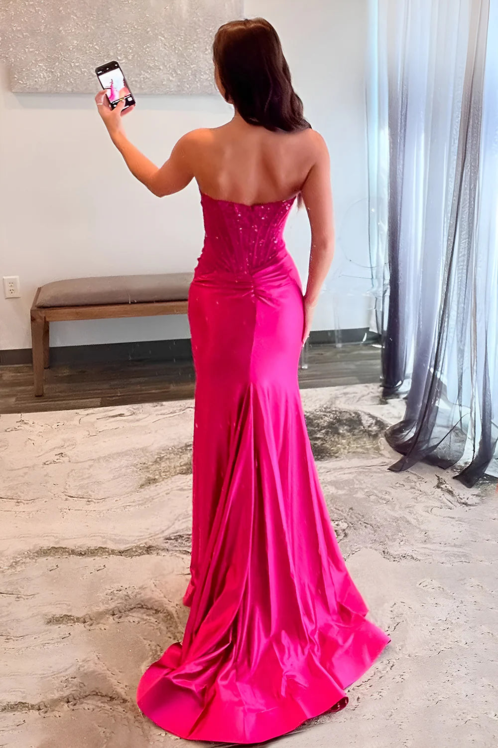 Side view of fuchsia satin prom dress showing mermaid silhouette and slit.