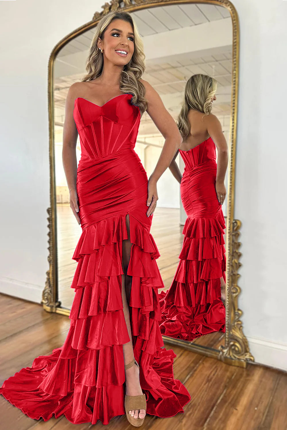 Model posing in a royal blue strapless mermaid prom dress with a flowing train.