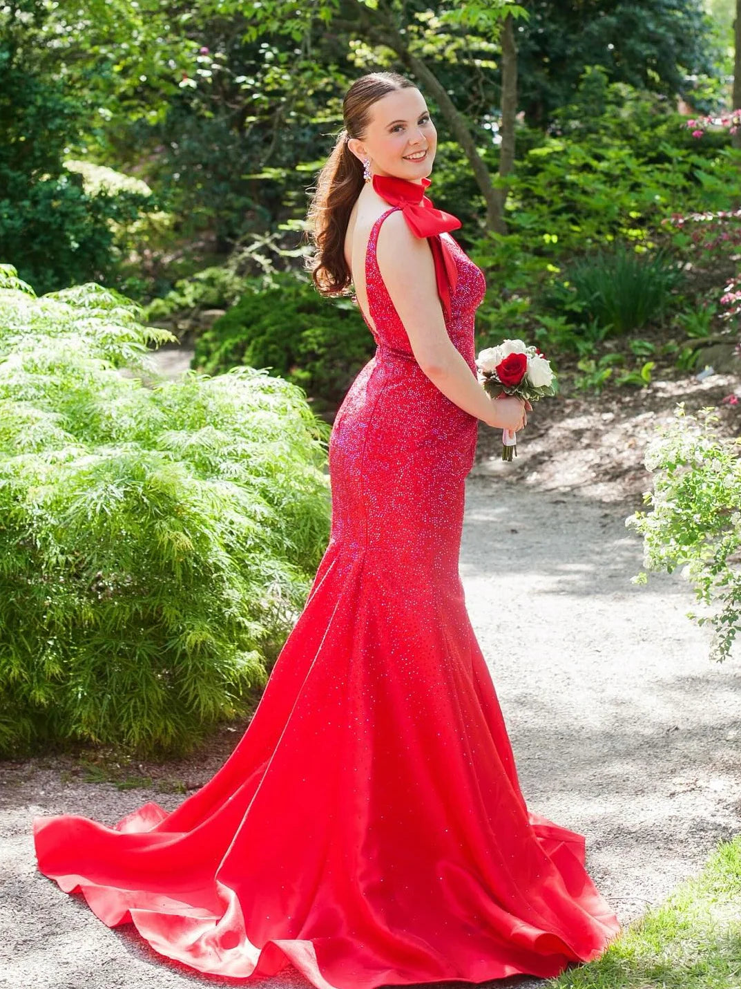 Side view of a model in a yellow mermaid gown, highlighting the silhouette and train.