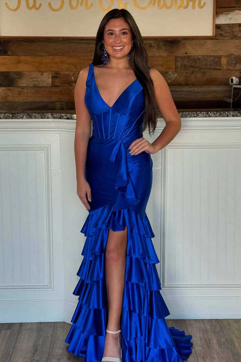 Side profile of a woman wearing the sage green satin mermaid gown.
