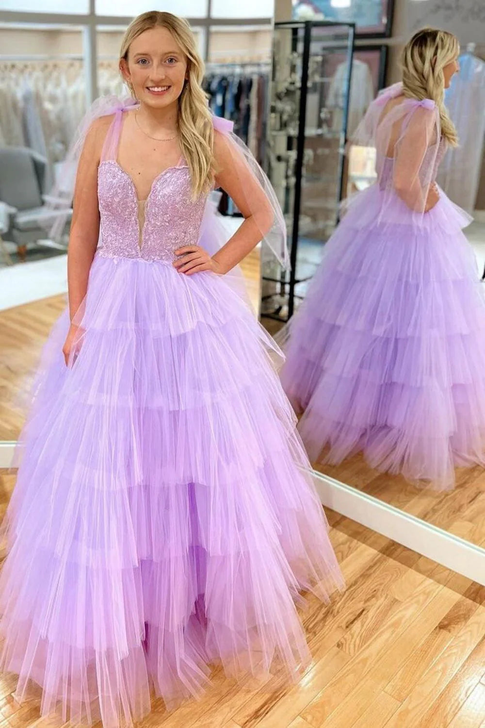 Full-length lilac A-line prom dress with spaghetti straps, appliques, and tiered ruffle tulle skirt.
