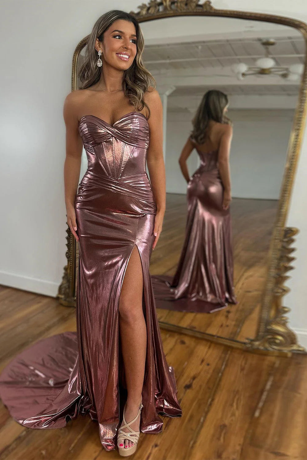 Model wearing a metallic magenta mermaid prom dress with a sweetheart neckline and thigh-high split.