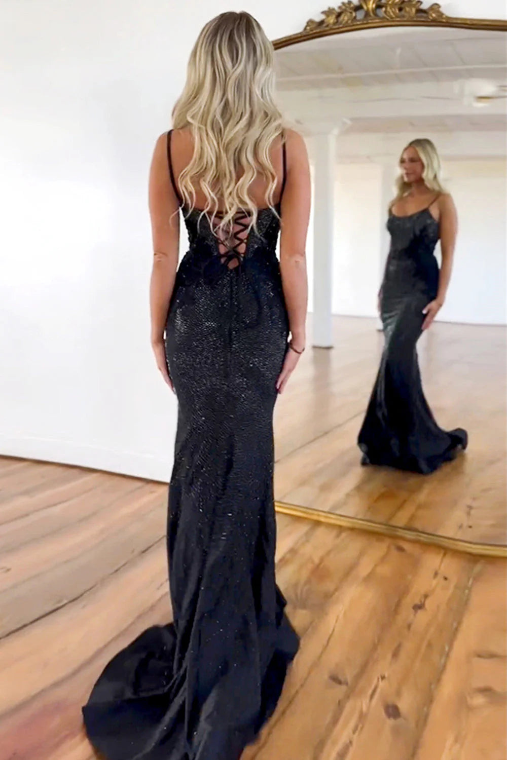Side view of the black mermaid prom dress, highlighting the lace-up back and flowing train.