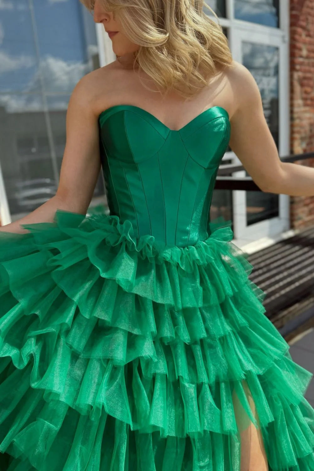 Back view of a green A-line sweetheart ruffled tiered prom dress with lace-up detail.