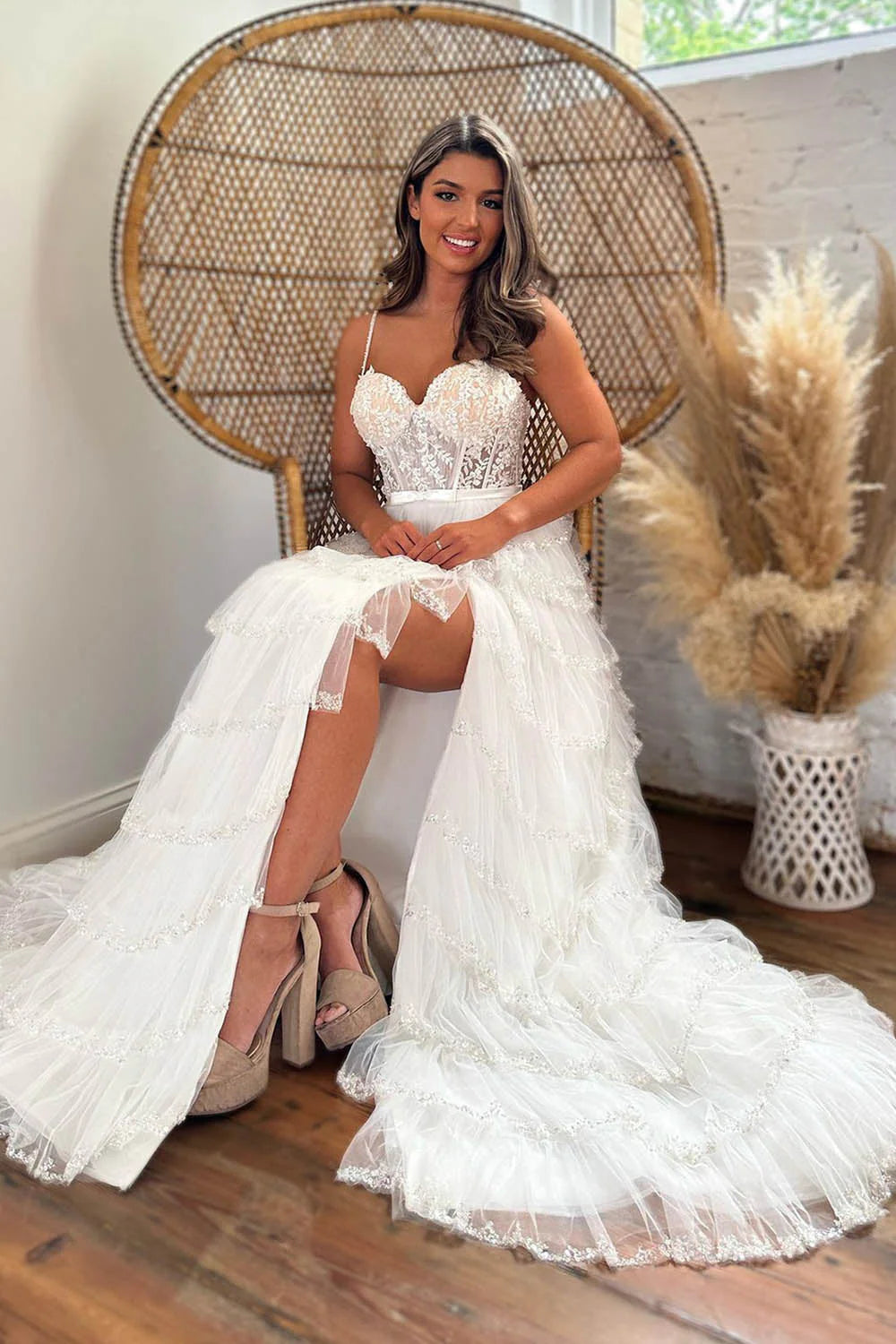 Model wearing a sparkling white A-line prom dress with spaghetti straps and tiered sequins.