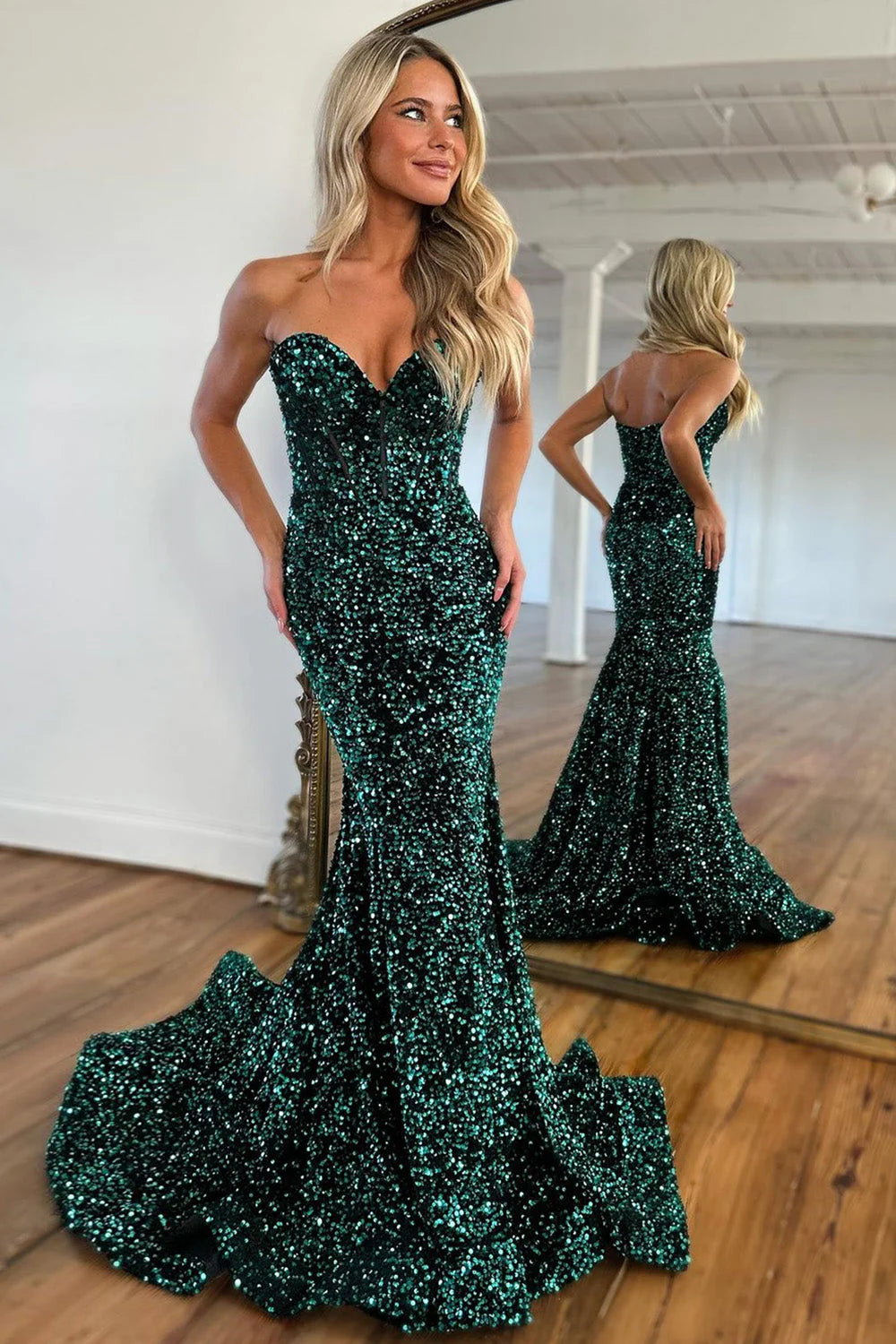 Model wearing a dark green sequin mermaid prom dress with a sweetheart neckline.